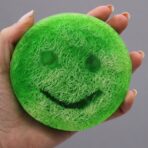 Roheline kooriv seep käes hoituna - naerunäoga luffa-seep näitab luffa-kiudude tekstuuri