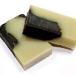 Võluv kaneeli käsitööseep viilutatud seebiplokk kookoskiuga valgel taustal