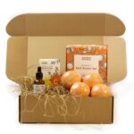 Kinkekomplekt jõuludeks avatud karbis nelja oranži vannipommiga