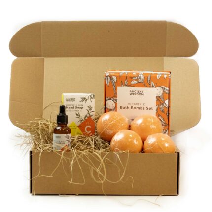 Kinkekomplekt jõuludeks avatud karbis nelja oranži vannipommiga