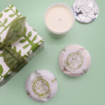 Kinkekomplekt naisele pealtvaates — küünal ja vannipommid rohelisel taustal