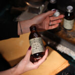 Loovuse aroomivesi Lady of the Lake pudel käes avatud korgiga