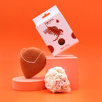 Punase savi konjac käsn — stiliseeritud tootefoto oranžil taustal