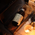 Rituaalvesi Caribbean Sea Water pudel nahkse reisikohvri sees