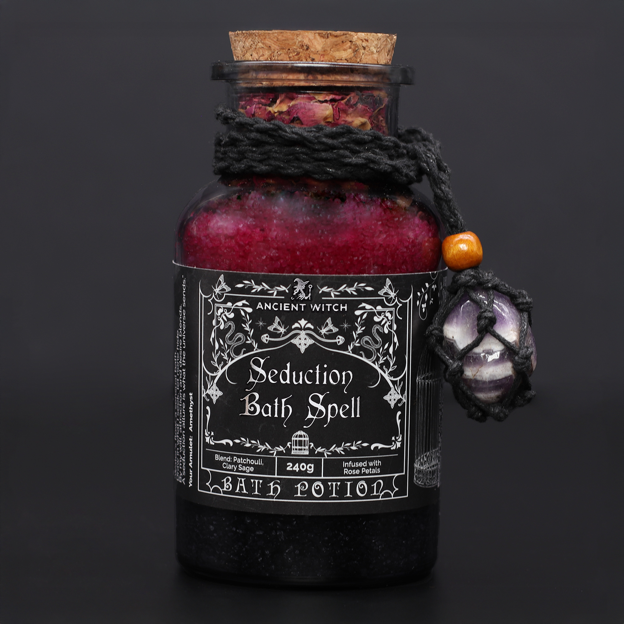 Ancient Witch Seduction võrgutuse rituaal klaaspudelis Võrgutuse rituaal Seduction Bath Spell punane pudel ametüsti kristalliga tumedal taustal